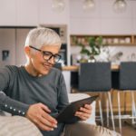 Beautiful older woman using tablet at home.