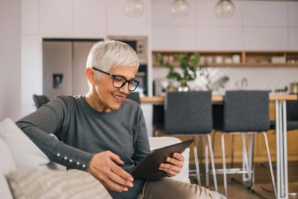 Beautiful older woman using tablet at home.