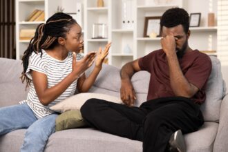 Young Couple Arguing On Sofa In Living Room Conflict